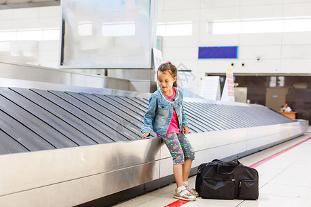在机场靠近行李报销手续的小女孩领取行李托图片
