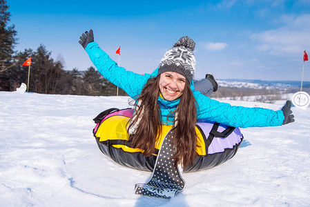 雪油管的年轻漂亮女人举起手来从雪山滑图片