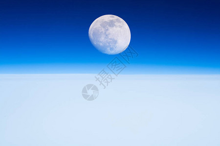 月亮从云层上方的平线升起背景图片