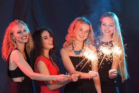 欢喜地庆祝一群带着烟火的开朗的年轻女新年假图片