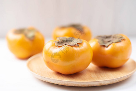 木盘上的熟柿子图片
