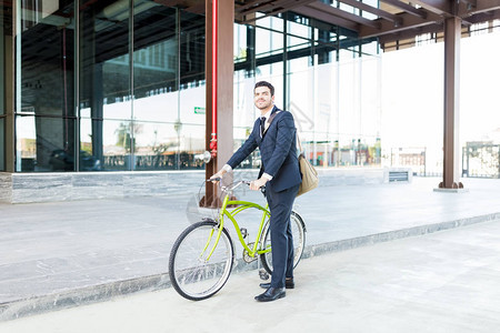 生态友好型商人与自行车站在城市图片