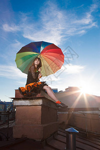 屋顶上有伞的年轻美女天空背景的浪漫步模特儿女图片