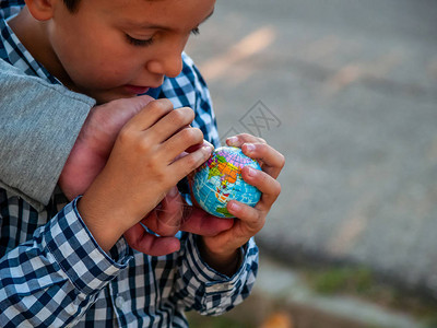 小朋友礼让一个拥有世界球或行星的童子手背景