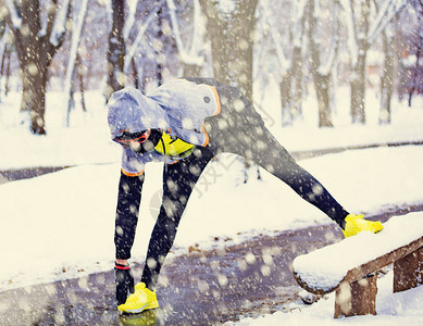 戴耳机跑步运动员在冬天的严寒时间背景