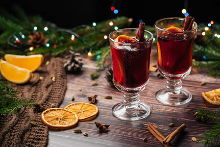 玻璃杯中含橙片肉桂棒和配有圣诞装饰品图片