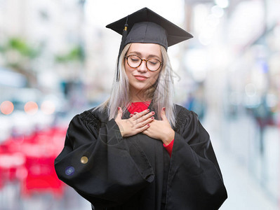 穿着研究生制服的金发年轻女子身穿孤立的背景图片