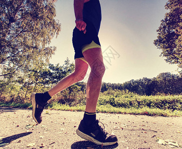 在公园路上的伸展跑步者穿着汗衫的慢跑者图片