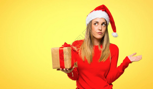 金发女人穿着衣服去圣诞节日怀疑和混淆黄色的面容表情图片