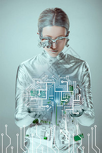 未来的银色机器人看着被灰色隔离的电路板图片