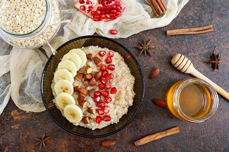 美味健康的燕麦片配香蕉石榴籽杏仁和肉桂健康的早餐健身食品适当的营养图片