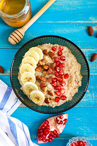 美味健康的燕麦片配香蕉石榴籽杏仁和肉桂健康的早餐健身食品适当的营养图片