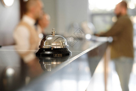 现代豪华酒店接待台与贝尔服务铃位于接待处桌子上的银色呼叫铃背景图片