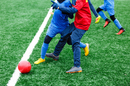 两名年轻的足球员跑步运球和争夺球权少年足球比赛冬季活动足球背景图片