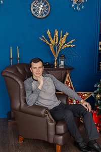 坐在新年房皮椅上的英俊帅哥图片