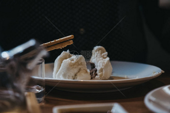 不明身份的人在吃烤肉的烧烤鸡肉包子图片