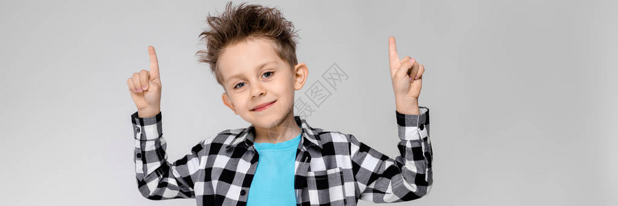 灰色背景的迷人快乐的孩子男孩的头发都竖起来了这个男孩有一个发型男孩用图片