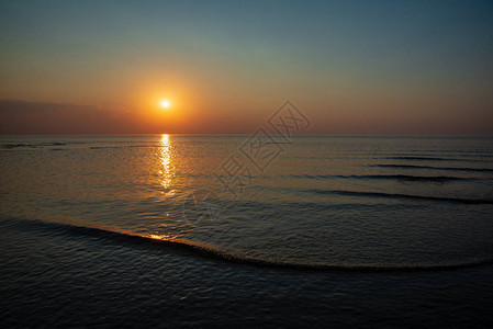 夏季在平静的海面上黄橙色日落阳光照耀图片