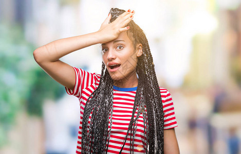 年轻的辫子头发非洲裔美国女孩在与世隔绝的背景下惊讶地用手在头上犯错图片