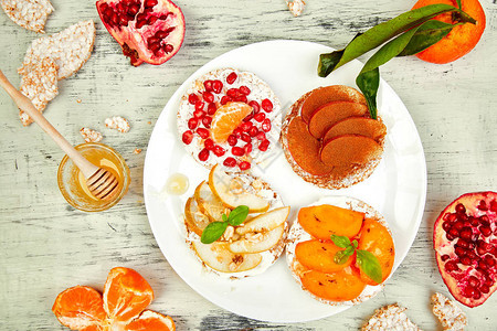 石榴橘子柿子苹果在白色背景上的简单早餐特写夏季素食主义者图片