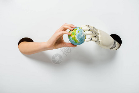 女和机器人通过白色环境中的孔洞持有地球模背景图片