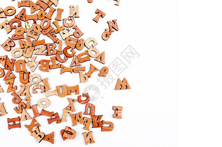 白色背景上散落的英文字母混合棕色木质字母图片
