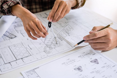 建筑工程或建筑师在工作现场检查建筑项目的绘图和素描会议信图片