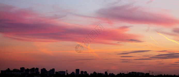 与戏剧天空日落的城市景观建筑工地的建筑物和起重机的轮廓城市图片