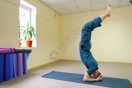 做瑜伽的年轻人体育运动员坐在房间的地板上图片