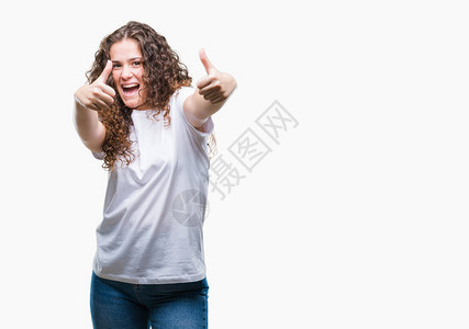美丽的黑发卷年轻女孩穿着休闲T恤在孤立的背景下批准用手做积极的手势图片