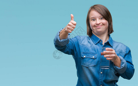 患有唐氏综合症的年轻成年女在与世隔绝的背景下喝水图片