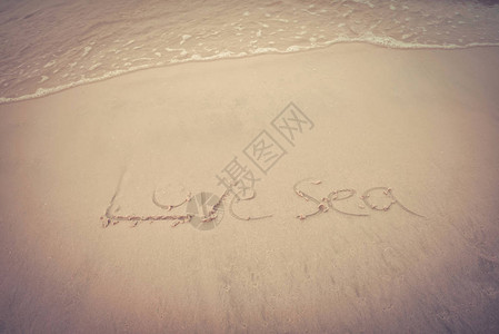 海滩纹背景沙滩上文字写着爱海在顶端的沙子上节图片