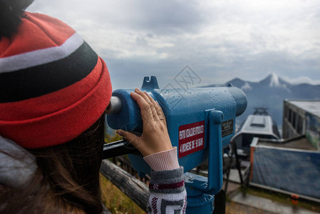 年轻女孩在山上望着双筒望远镜看望平图片