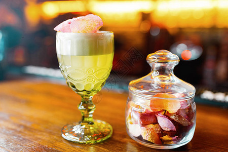 餐厅的桌子上摆着带有马提尼酒和伏特加的甜黄绿色水果糖浆图片