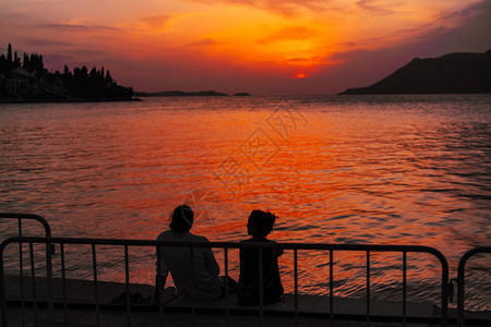 年轻夫妇坐在沙滩上看日落图片