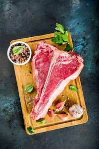 剪纸花纹生鲜新肉T骨牛肉排和香料及切菜板上草药背景