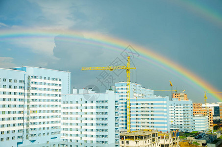 七彩虹在城市高层建筑上空延伸背景