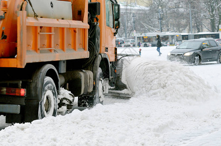 晚上在城市下雪了他的清洁去了除雪车他们清理了城市背景图片