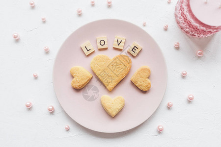 爱的言语和心灵在粉红盘子上的黄油饼干和情人节装饰粉红珍图片
