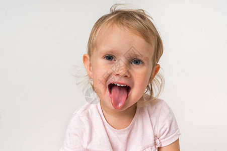 在孤立的背景下露出舌头的小女婴背景图片