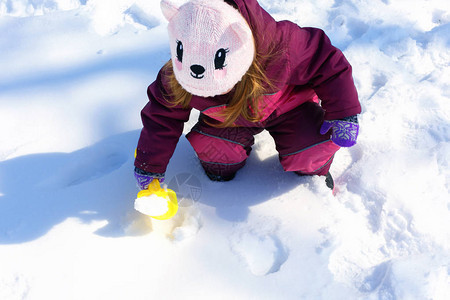 可爱的小女孩在冬季公园堆雪人可爱的孩子在雪地里玩耍孩子们的冬季活动在寒冷的日子在户外玩图片