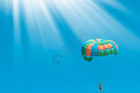 在蓝天背景的一个五颜六色的降落伞美丽的夏天背景度假的积极假期健图片