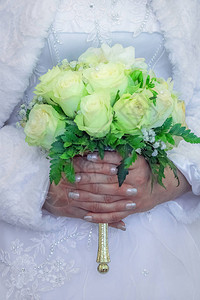 新娘手里拿着白玫瑰的婚礼花束柔和的玫瑰图片