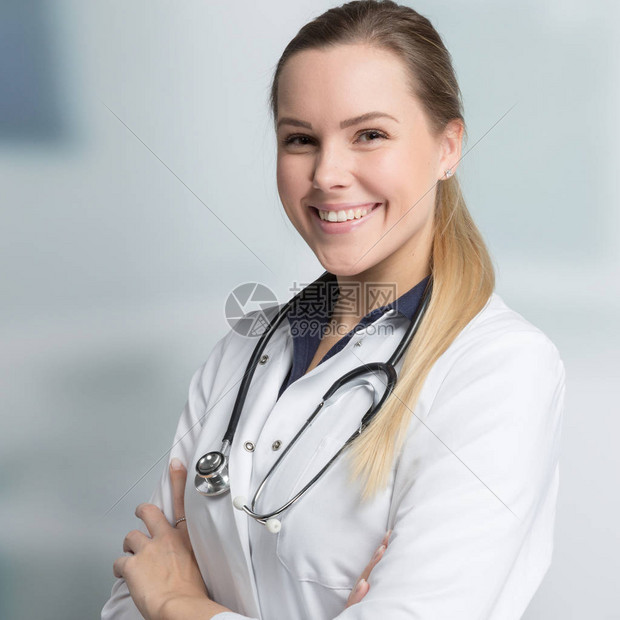 年轻笑着微笑的女医生在门诊室背景图片