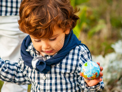 小朋友礼让一个拥有世界球或行星地球的童子手背景