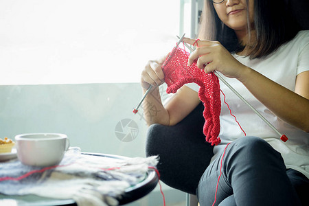 服装展览年轻女人坐在家里织衣服背景