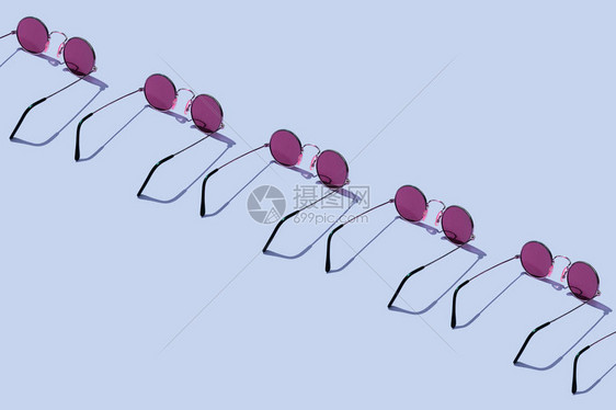 在蓝色背景上组织的圆形太阳镜图片