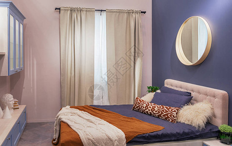 现代卧室配有米色窗帘蓝色墙壁和大床图片