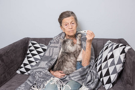 一位白发苍皱纹深邃的高加索老奶正坐在家里的沙发上图片