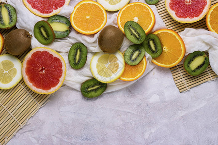 新鲜的热带水果葡萄柚柠檬橙子猕猴桃在轻石背景上图片